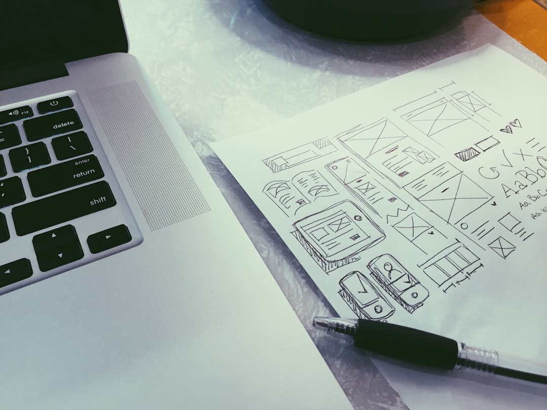 ball-point-pen-on-paper-beside-macbook-zklwygsehzi